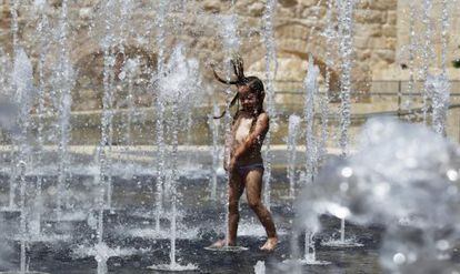 Una niña juega en una fuente en Jerusalén (Israel). Una ola de calor sacude Israel con temperaturas de hasta 45ºC.