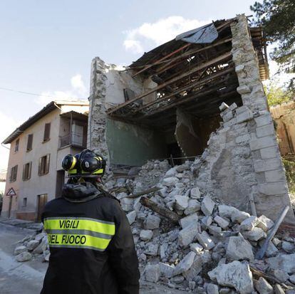 Un bombero junto a los escombros de un edificio en el Visso (Italia).