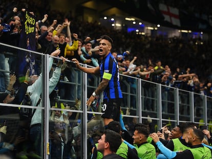 El argentino del Inter Lautaro Martínez celebra su gol ante el Milan subido a la valla que separa el césped de los aficionados en el estadio Giuseppe Meazza.