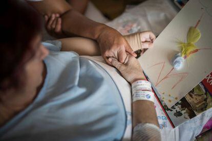 La Lourdes agafa la mà de la seva artterapeuta, amb el dibuix titulat “Resistiré”.