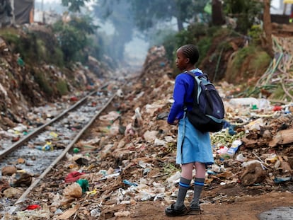 Una estudiante junto a la línea ferroviaria Kenia-Uganda a su paso por Nairobi ataviada con el uniforme del colegio.