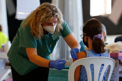 Una enfermera vacuna a una niña contra la covid-19 en Granada.