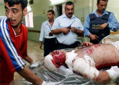 Un iraquí herido grave ayer en un atentado suicida entra en una camilla en el hospital de Yarmuk, en Bagdad.