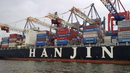 Un buque de carga de la naviera Hanjin bajo varias gr&uacute;as durante el proceso de carga en el puerto de Hamburgo.