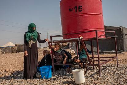 Una mujer de Homs desplazada en el campamento de Al Alsadya, cerca de la ciudad de Raqa. La mujer llena un cubo para las necesidades domésticas en el tanque del campamento. El depósito es la única fuente de agua disponible.
