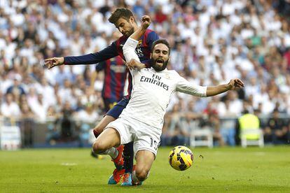 El defensa del Real Madrid Daniel Carvajal lucha un balón con el defensa del FC Barcelona Gerard Piqué.