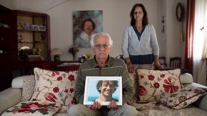 Manuel Sierra porta una foto de su hijo Manuel, fallecido en el accidente del Alvia, en su casa de Valladolid y con su hija María Dolores al fondo.
