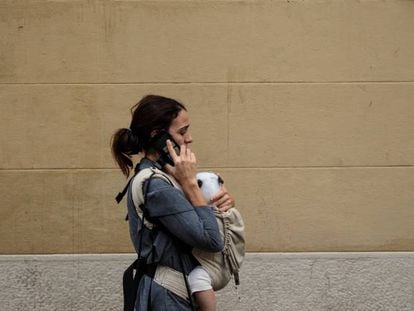 Una mujer pasea con su bebé por Barcelona.