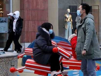 Personas con mascarillas protectoras en un centro comercial de Pekín. 