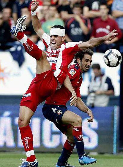 El jugador de Osasuna Juanfran pelea por un balón con el del Sporting Bilic.