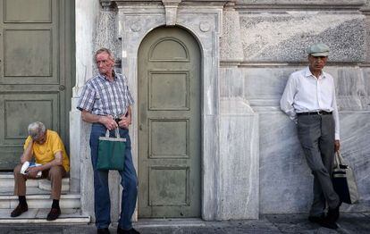 Tres pensionistas aguardan fuera de la sede del Banco Nacional de Grecia, el 9 de julio.