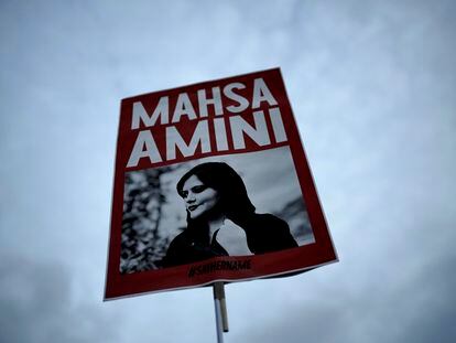 FILE - A woman holds a placard with a picture of Iranian Mahsa Amini as she attends a protest against her death, in Berlin, Germany, Wednesday, Sept. 28, 2022.   Nasreen Shakarami, the mother of Amini, said Friday, Oct. 7,  the teen was killed by repeated blows to the head as part of Iran's crackdown on anti-hijab protests roiling the country. Shakarami also said authorities kept her daughter Nika’s death a secret for nine days and then snatched the body from a morgue to bury her in a remote area, against the family’s wishes.  (AP Photo/Markus Schreiber)