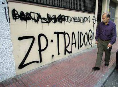 Un viandante observa las pintadas efectuadas en la fachada de la sede del PSOE en Getafe.