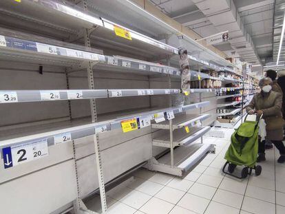  Una mujer observa unas estanterías vacías de legumbres en un supermercado de Madrid. Efe 