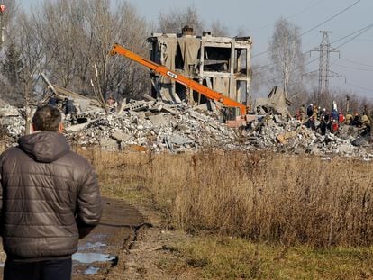 Un hombre observa cómo unos trabajadores retiran los escombros de un edificio donde murieron decenas de soldados rusos esta Nochevieja tras un ataque con misiles ucranianos, en Makiivka, municipio del este de Ucrania controlado por Rusia.