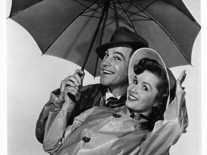 Gene Kelly y Debbie Reynolds posan junto a un paraguas en la película 'Cantando bajo la lluvia', en 1952.