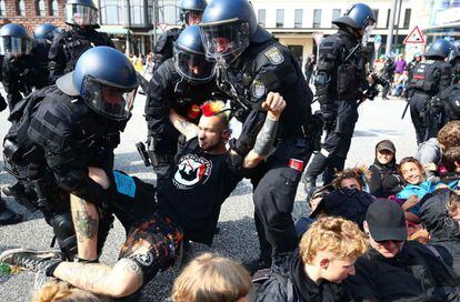 La policía retira a un manifestante de una calle bloqueada.