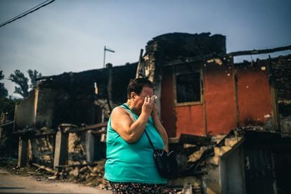 A woman weeps this Wednesday at the state in which houses were left in the village of Alixo in Galicia, where flames engulfed fifteen houses on Sunday and Monday. 