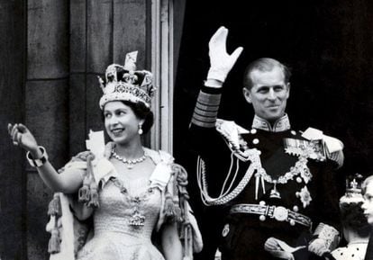 Imagen de la reina Isabel II de Inglaterra, en la que lleva la corona imperial del Estado, mientras su marido, el Duque de Edimburgo, lleva el uniforme de Admirante de la Armada, en el balcón del Palacio de Buckingham en Londres (Reino Unido), después de la coronación de la reina en la Abadia de Westminster, el 2 de junio de 1953.