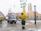 Dos trabajadores del ayuntamiento de Bullas esparcen sal para evitar que la nieve se convierta en hielo, este jueves, en la plaza del Ayuntamiento de Bullas (Murcia).