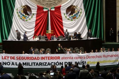 Álvarez Máynez habla en el Congreso mientras diputados muestran una pancarta contra la Ley de Seguridad Interior, en noviembre de 2017.