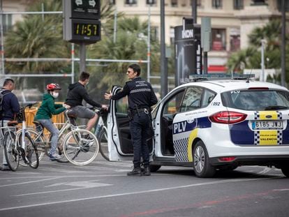 La policía de Valencia advierte a unos paseantes de que tienen que quedarse en casa. En vídeo, Pedro Sánchez responde a la pregunta de cómo se garantizará que los ciudadanos cumplan las restricciones.