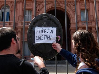 Dos hombres dejan una flor en la Casa Rosada, en Buenos Aires.