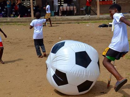 Un nen xuta una pilota inflable al barri de Port Bouët, a Abidjan.