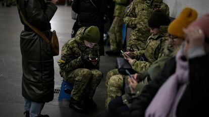 Varias personas se refugian en una estación de metro mientras suenan las alarmas antiaéreas, este viernes en Kiev.