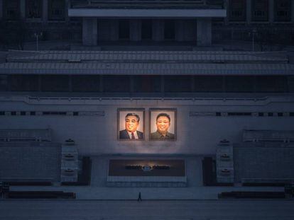 Un ciudadano pasea debajo de los dos grandes retratos de Kim Il-Sung (izq.) y Kim Jong-Il (der.) en Pyongyang.