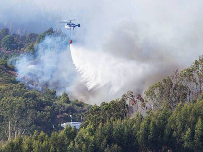 Un helicóptero realiza labores de extinción en la localidad de Guía.
