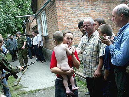 Una mujer con un niño en brazos llora en el momento de ser liberada del secuestro en una escuela de Beslán.