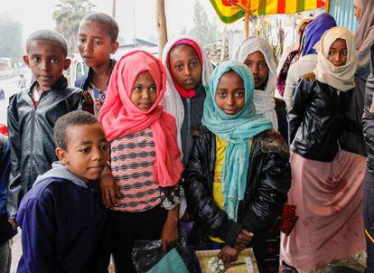 Un grupo de menores se protege de la lluvia bajo un toldo poco antes de empezar la jornada escolar, en una población situada entre Dessie y Weldiya (región de Amhara).