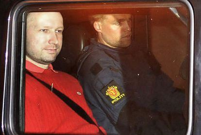 Anders Behring Breivik abandona ayer el juzgado de Oslo custodiado por un policía.