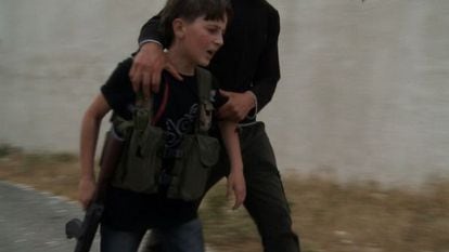 Un ni&ntilde;o armado con un fusil AK-47 durante los combates la oposici&oacute;n siria. El ni&ntilde;o llora por la muerte de su padre.