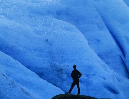 Un turista ante el hielo azul del glaciar Svartisen, al norte de Noruega.