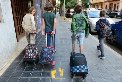 Cuatro niños se dirigen al colegio López Rosat de Valencia por una de las vías seguras del Colecamins.