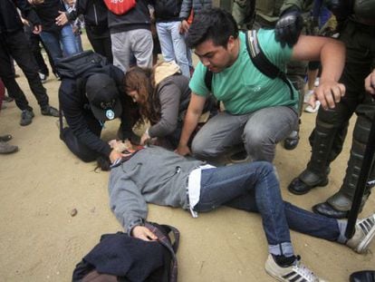 Manifestantes ayudan a uno de los jóvenes tiroteados este jueves.