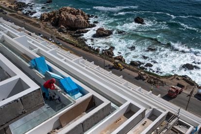 Una trabajadora de la construcción limpia los ventanales de una nueva edificación al costado del borde costero de Valparaíso, el 5 de diciembre de 2022.