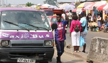 Un chico togolés vende agua potable fría en una parada de taxis de Libreville el 25 de junio de 2018.