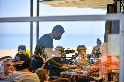 Un camarero sirve a unos clientes de una mesa de un restaurante del Paseo Marítimo de Platja d'Aro.