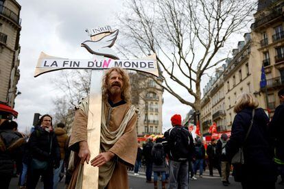 Un manifestante sostiene una cruz con una nota que dice "El fin del mundo" durante la manifestación en París contra el plan de reforma de pensiones.