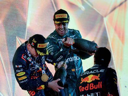Third place winner Aston Martin's Spanish driver Fernando Alonso (C) sprays with champagne race winner Red Bull Racing's Dutch driver Max Verstappen (L) on the podium after the Bahrain Formula One Grand Prix at the Bahrain International Circuit in Sakhir on March 5, 2023. (Photo by Giuseppe CACACE / AFP)