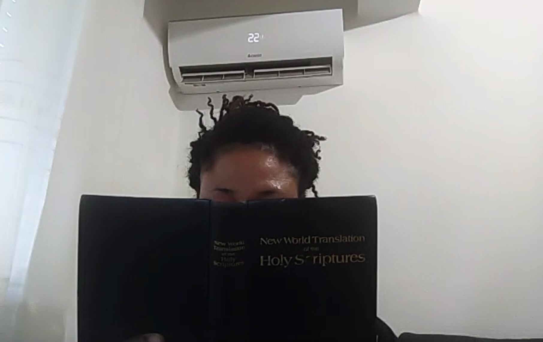 Naomi (nombre ficticio) se tapa el rostro con una biblia.