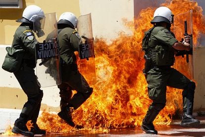 Varios policías tratan de un huir de un cóctel molotov en una manifestación en Atenas