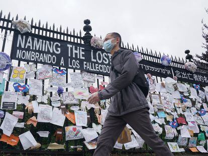 Un hombre pasa ante una verja con mensajes por la memoria de los fallecidos en Nueva York.