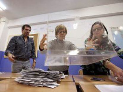 Miembros de una mesa electoral en un colegio de Vitoria vac&iacute;an la urna.