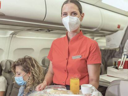 Viajeras y tripulantes de cabina con mascarilla a bordo de un avión de Iberia.