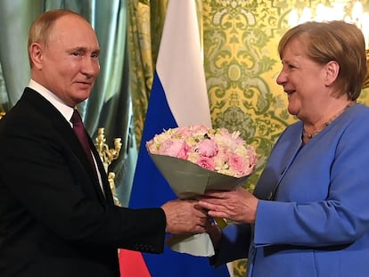 El presidente ruso, Vladimir Putin, recibe a la canciller alemana, Angela Merkel, con un ramo de flores durante su encuentro en el Kremlin, en Moscú.