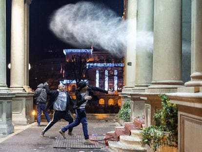 Manifestantes arrojan piedras contra el ayuntamiento de Belgrado, durante la protesta por el supuesto fraude electoral de este domingo en la capital serbia.